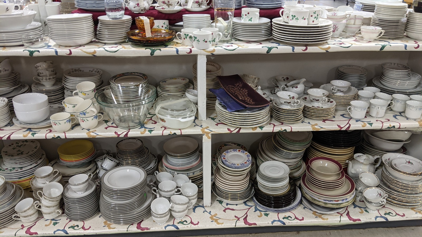 Patterned china and serving pieces arranged together on shelves