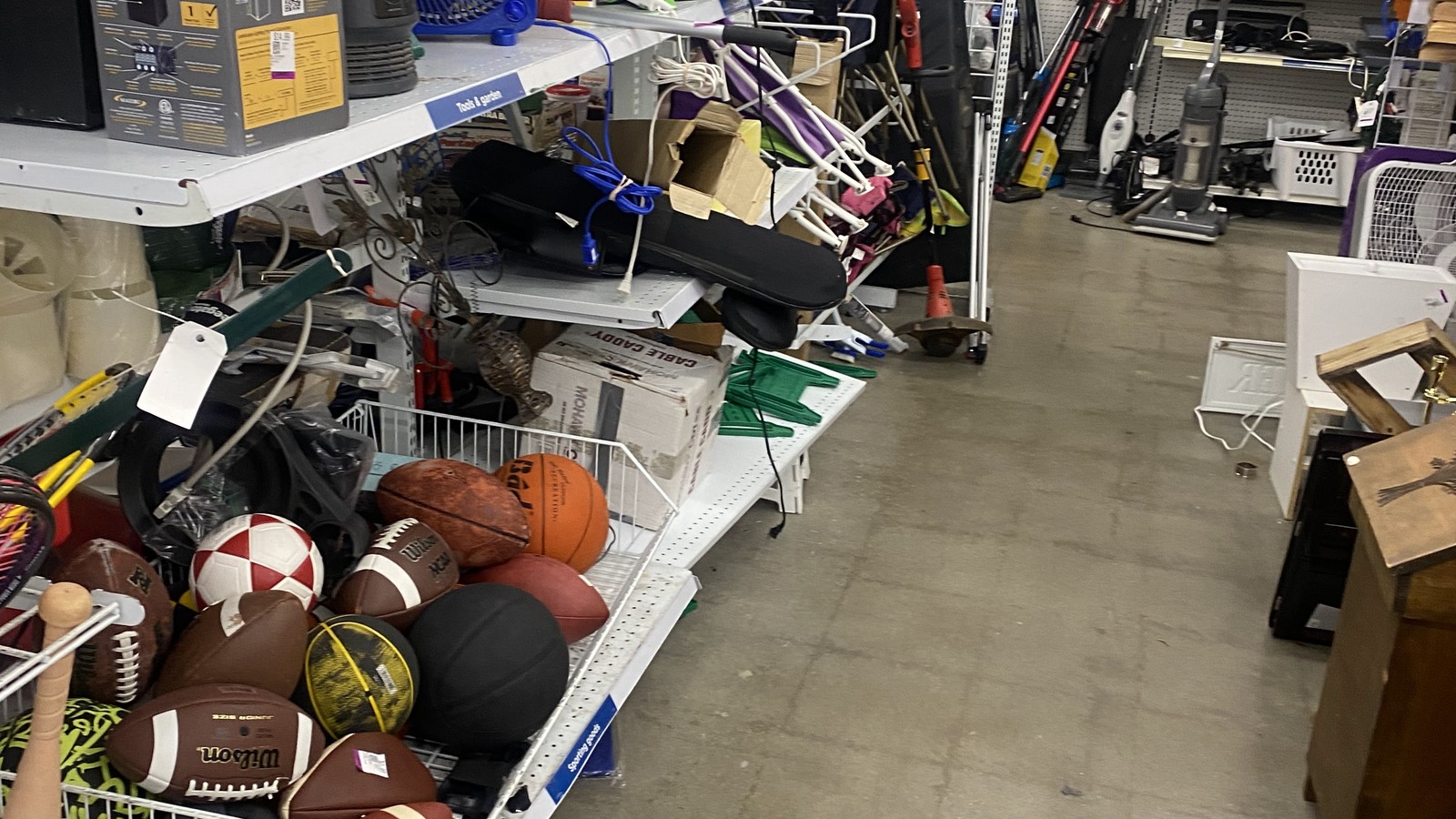Sporting goods and toys grouped along a Savers aisle