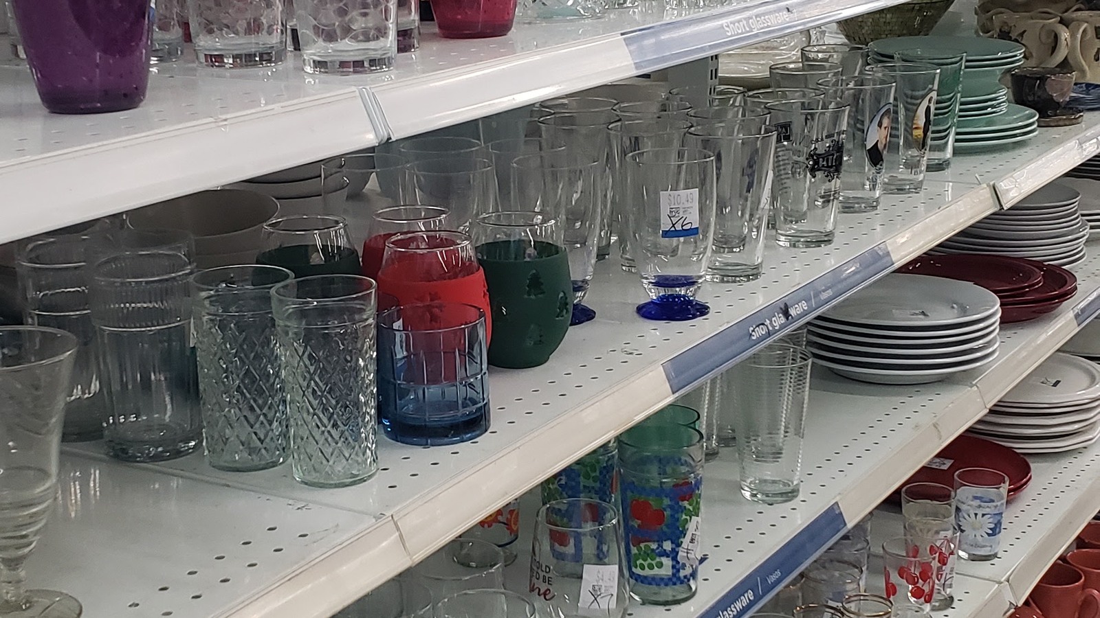 Colorful drinking glasses and dishes on housewares shelves