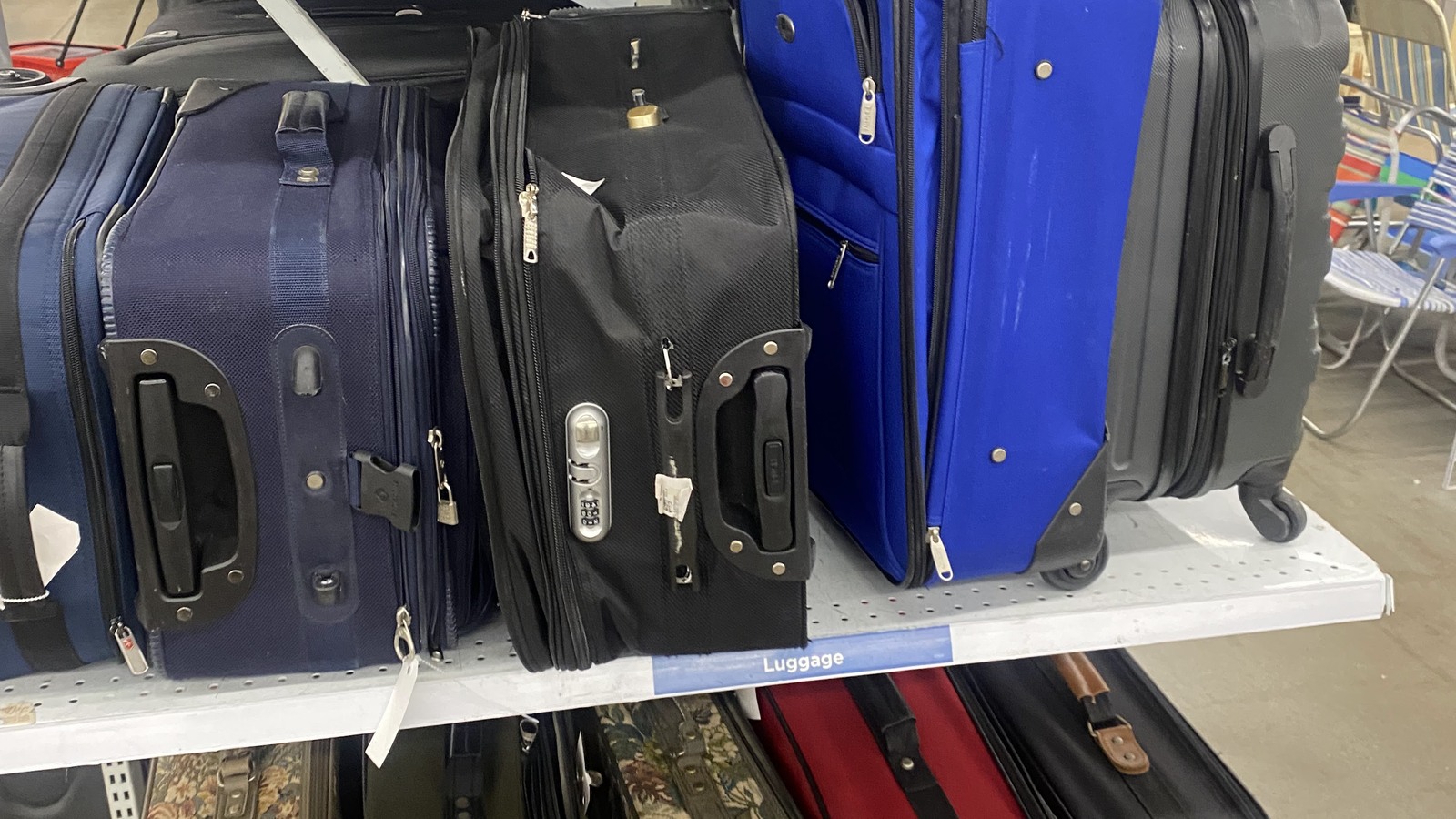 Rolling suitcases and travel bags lined up on a shelf