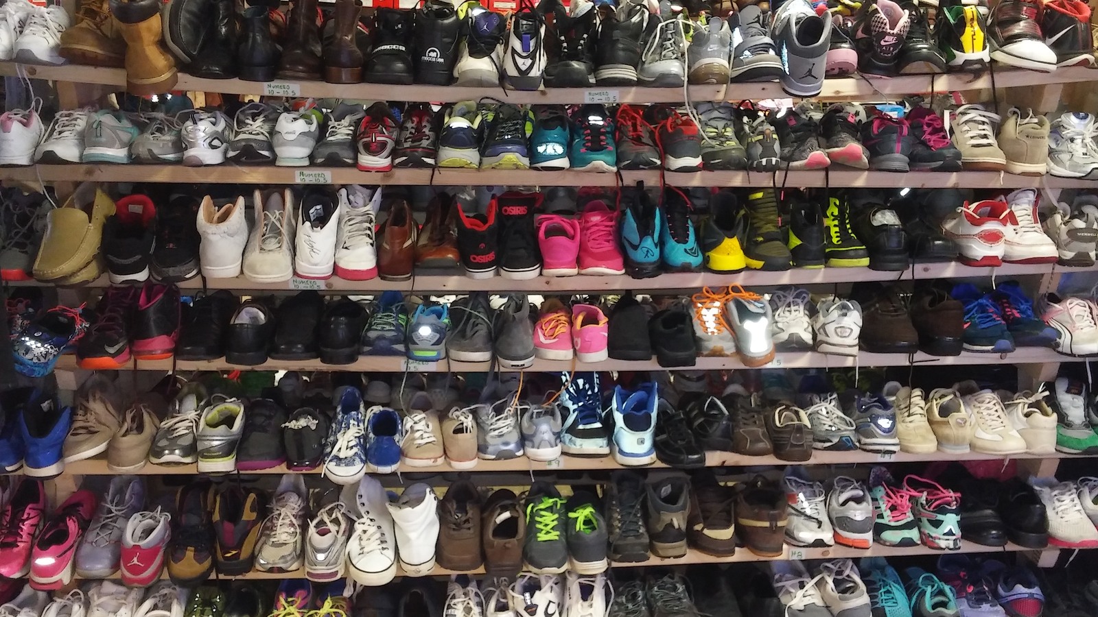 Colorful rows of shoes arranged along a tall wall