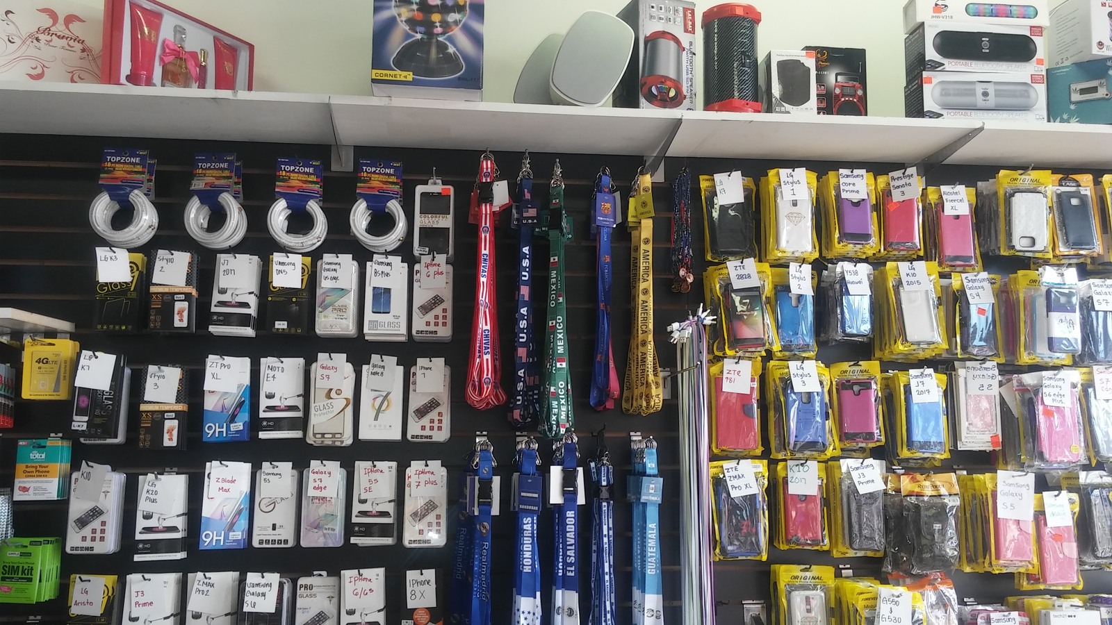 Phone accessories and compact electronics arranged on a display wall