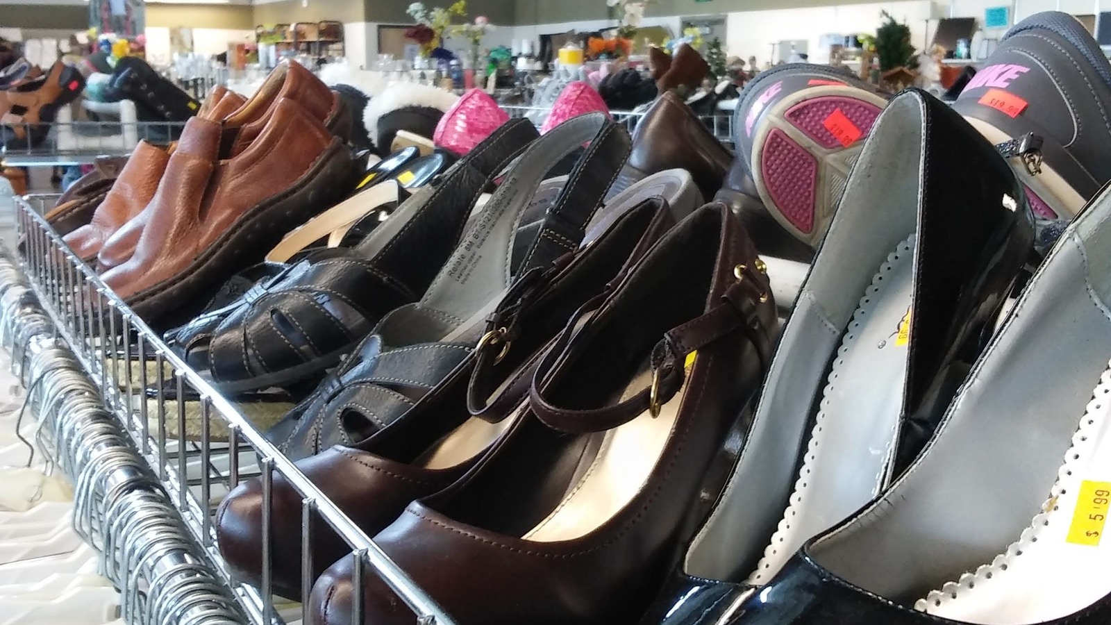 Dress shoes and sandals arranged on a rolling rack