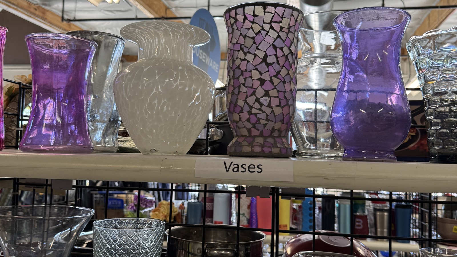 Purple and clear decorative vases on a shelf