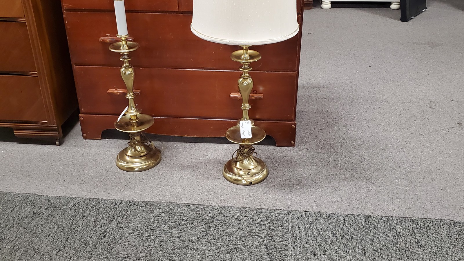 Matching brass table lamps beside wood furniture