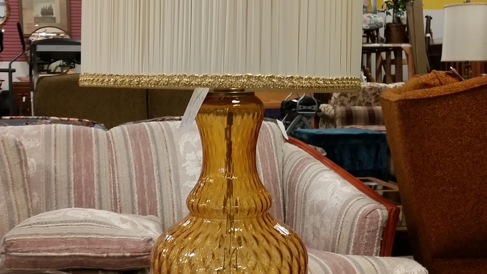 Amber glass lamp among upholstered chairs and home furnishings