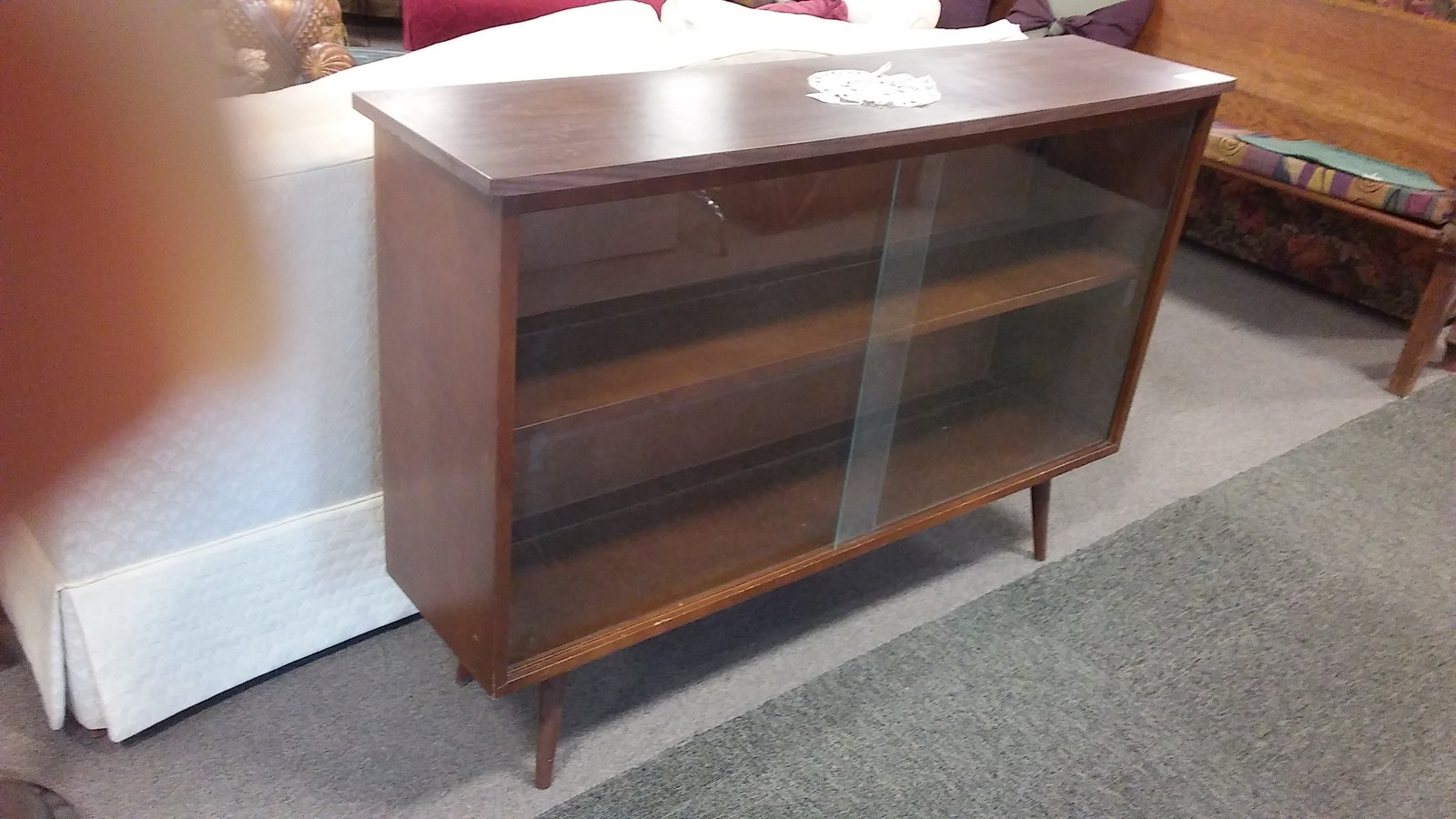 Low wood cabinet with sliding glass doors and tapered legs