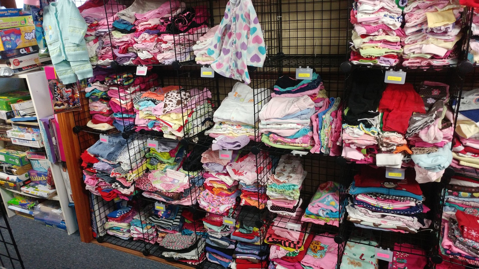 Colorful children's clothing arranged on shelves at One More Time Thrift And Consignment in Oak Ridge