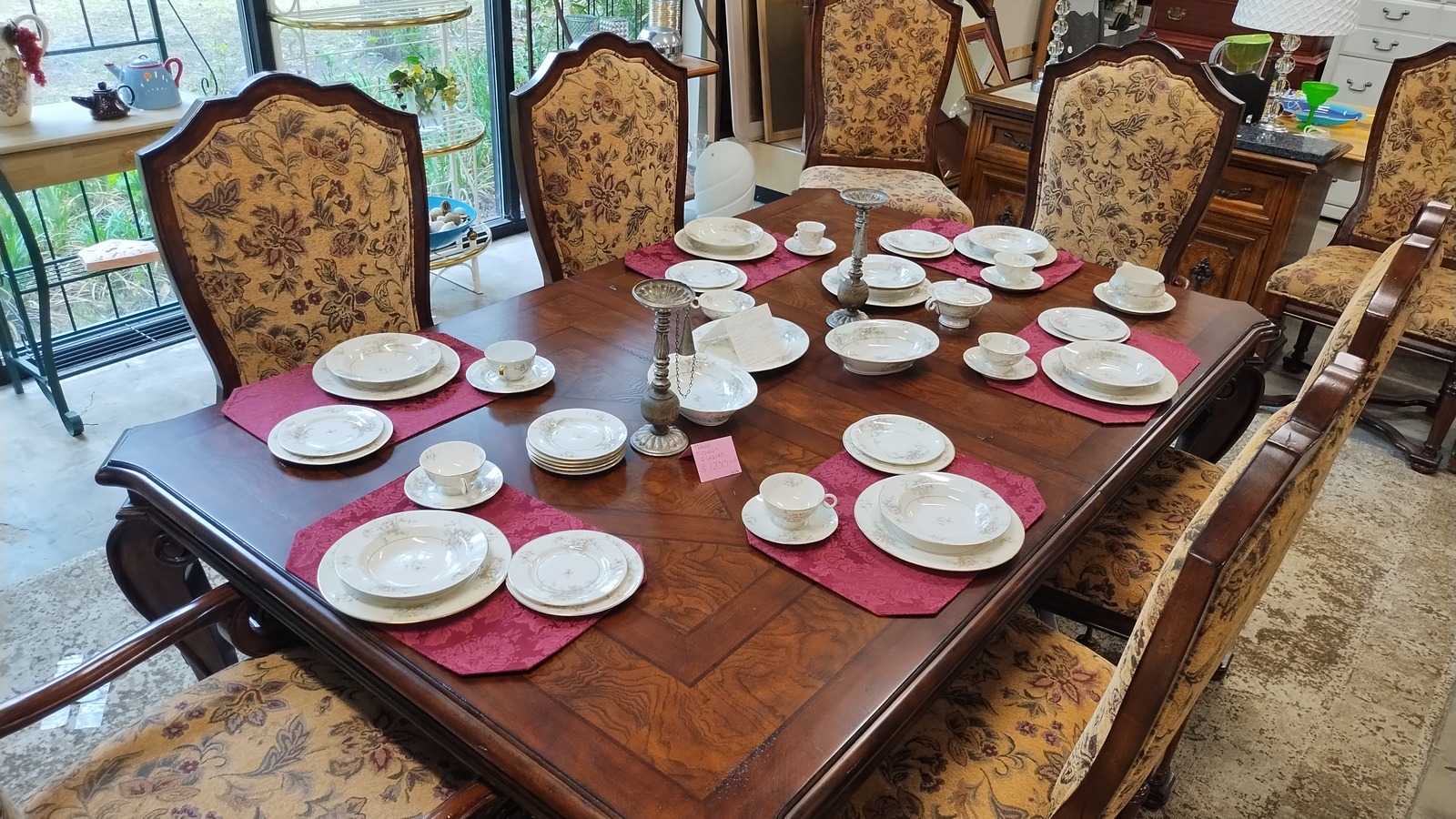 Dining table with china and upholstered chairs at Osprey Village Thrift on Main