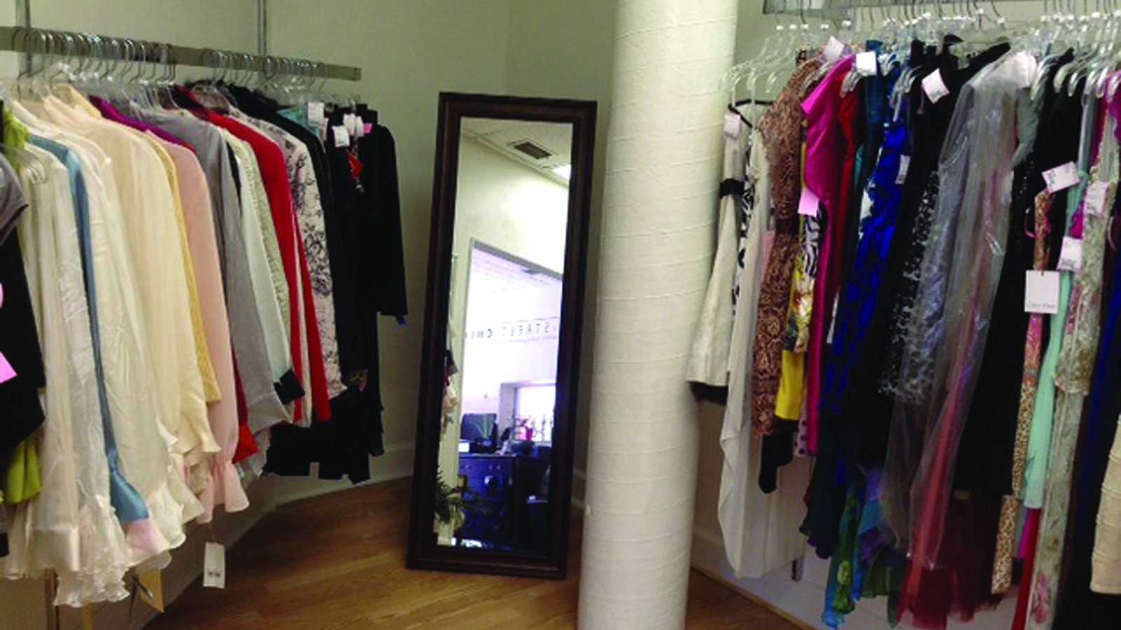 Designer clothing arranged around a full-length mirror at Canal Street Chic
