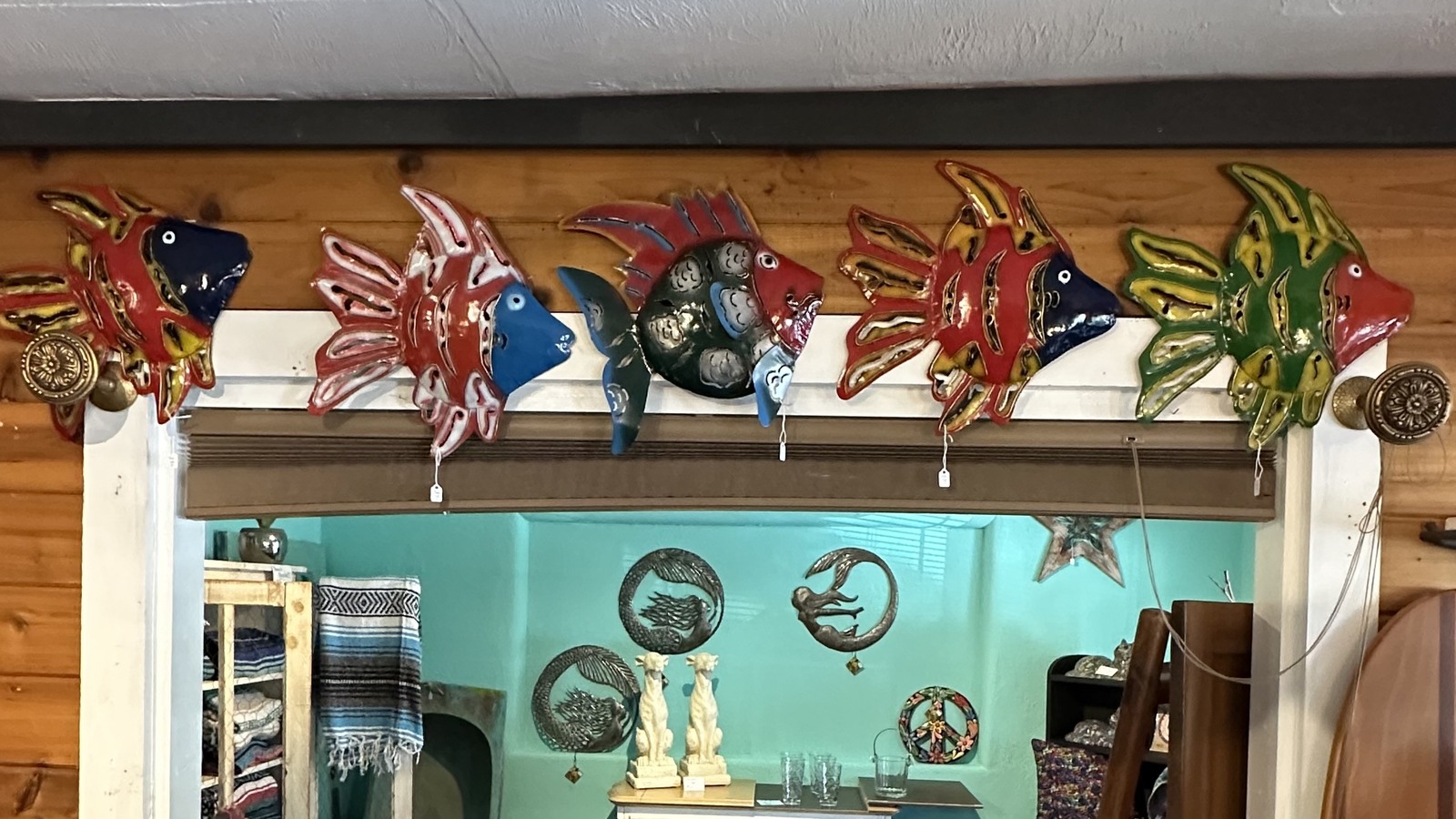 Colorful fish wall decor and coastal accents inside The Vintage Mermaid