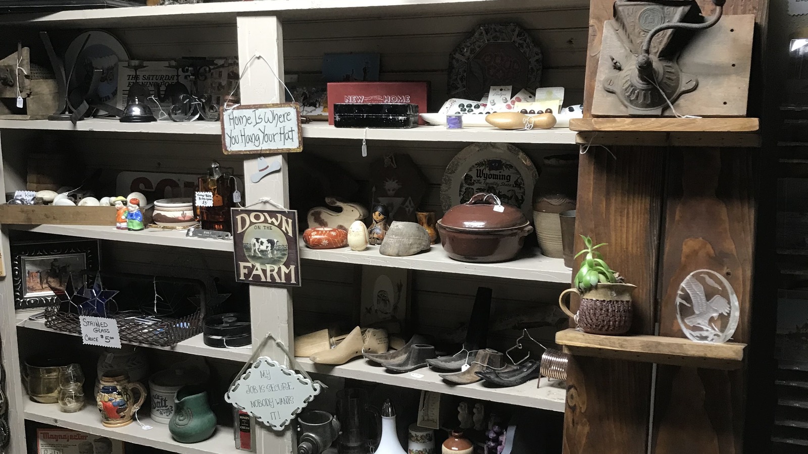 Pottery and home decor displayed on shelves at CODY UNiQUES in Cody