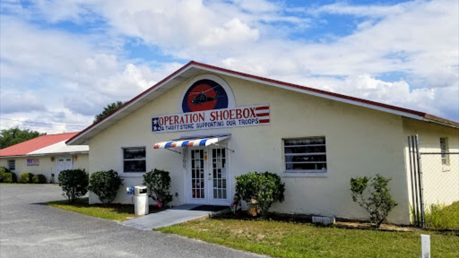 Operation Shoebox thrift store entrance beneath a blue Florida sky in Belleview