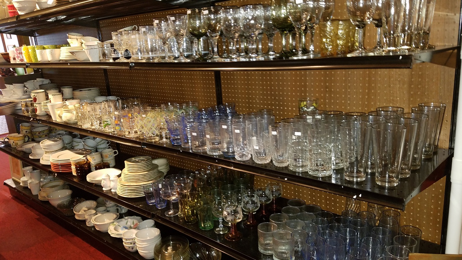 Shelves of glassware, dishes, and serving pieces at St. Theresa Thrift Shop in Belleview