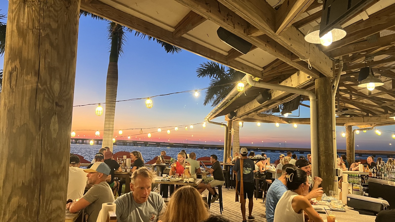 Covered open-air bar and dining room at Salt Shack On The Bay at dusk
