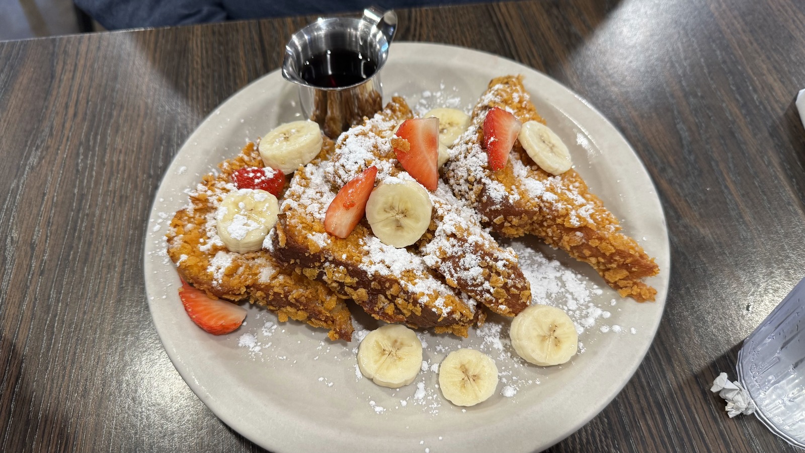 French toast topped with strawberries, bananas, and powdered sugar at Flat Tire Diner