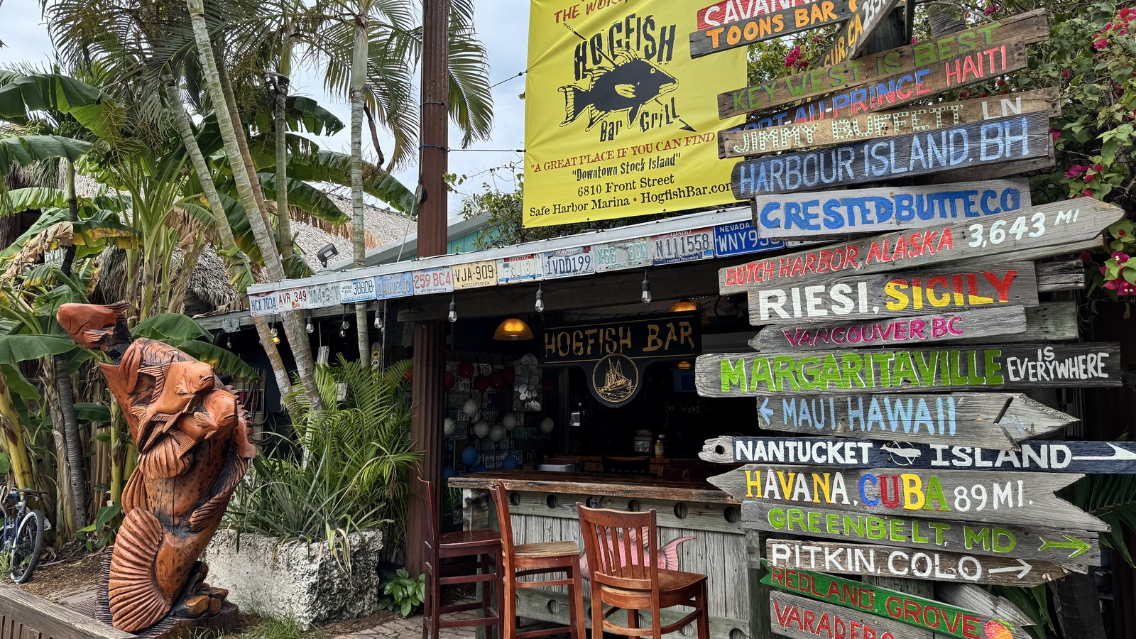 Hogfish Bar & Grill welcome sign and colorful destination posts on Stock Island