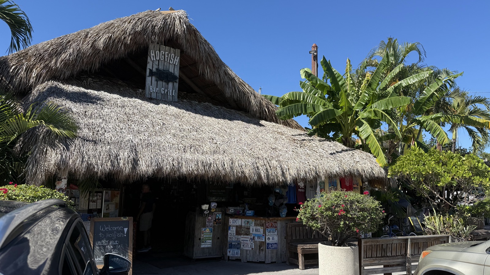 Palm-thatched exterior of Hogfish Bar & Grill under a bright blue Key West sky