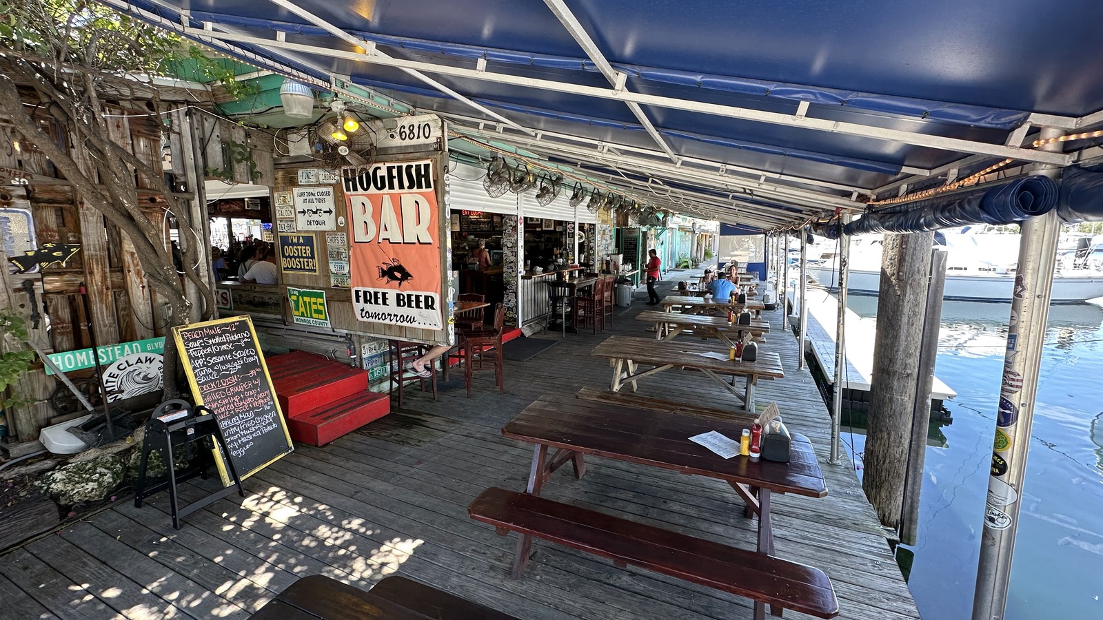 Dockside picnic tables stretching beside the marina at Hogfish Bar & Grill