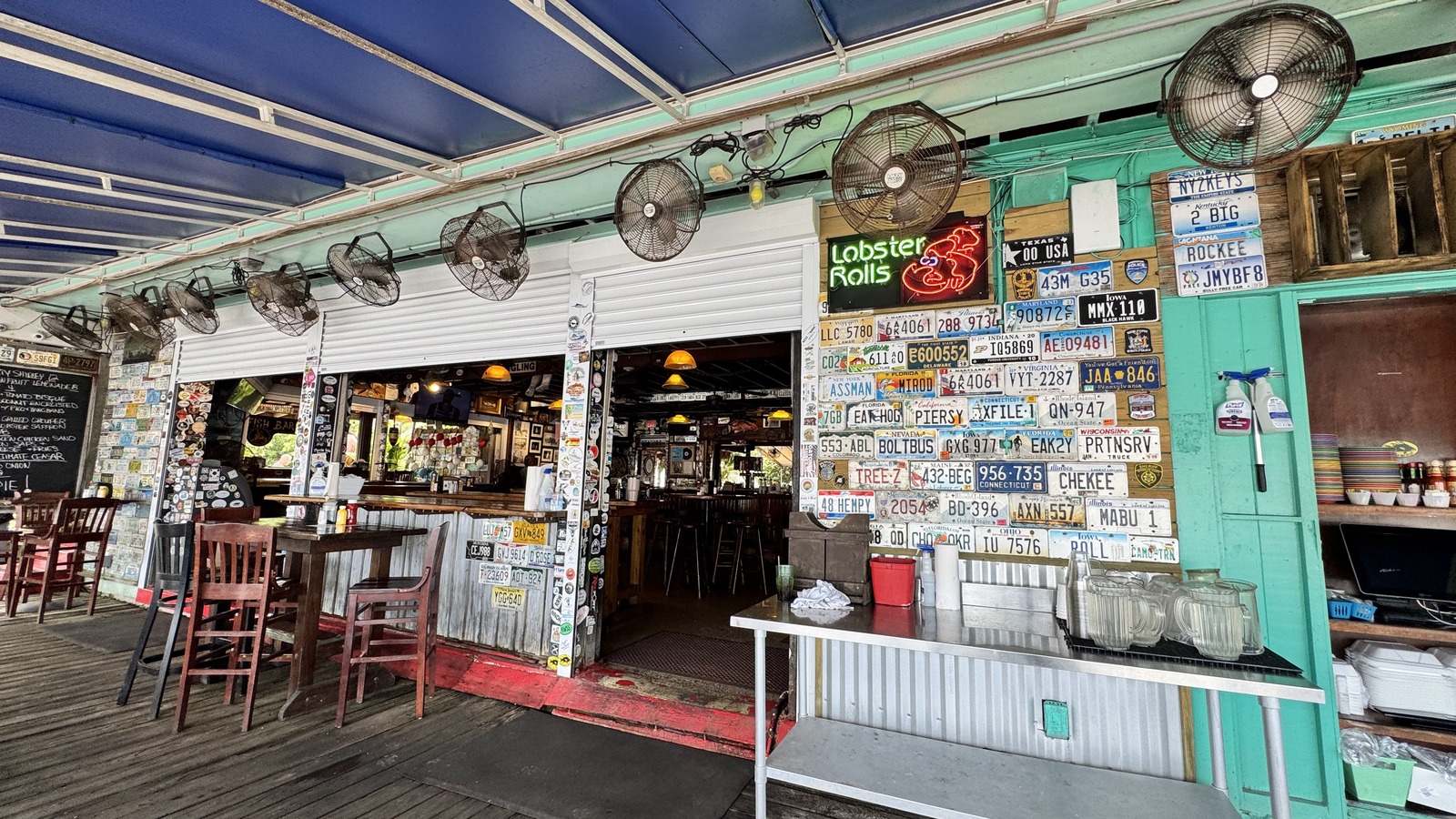 Turquoise open-air bar and license-plate wall at Hogfish Bar & Grill