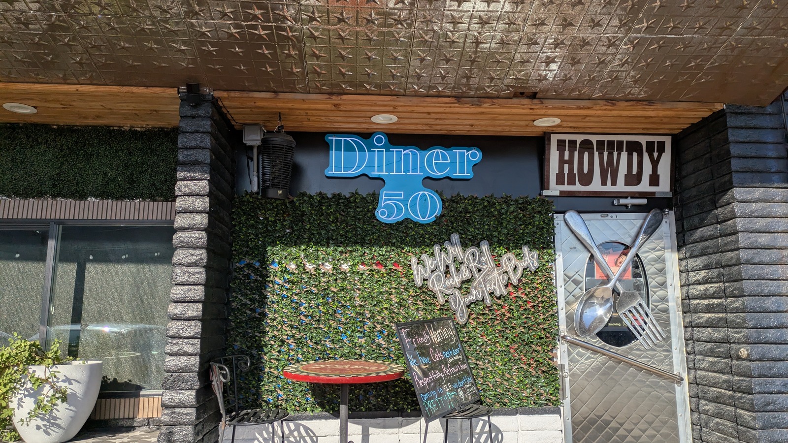 Diner 50 entrance with blue sign and oversized fork-and-spoon door handles in Phoenix