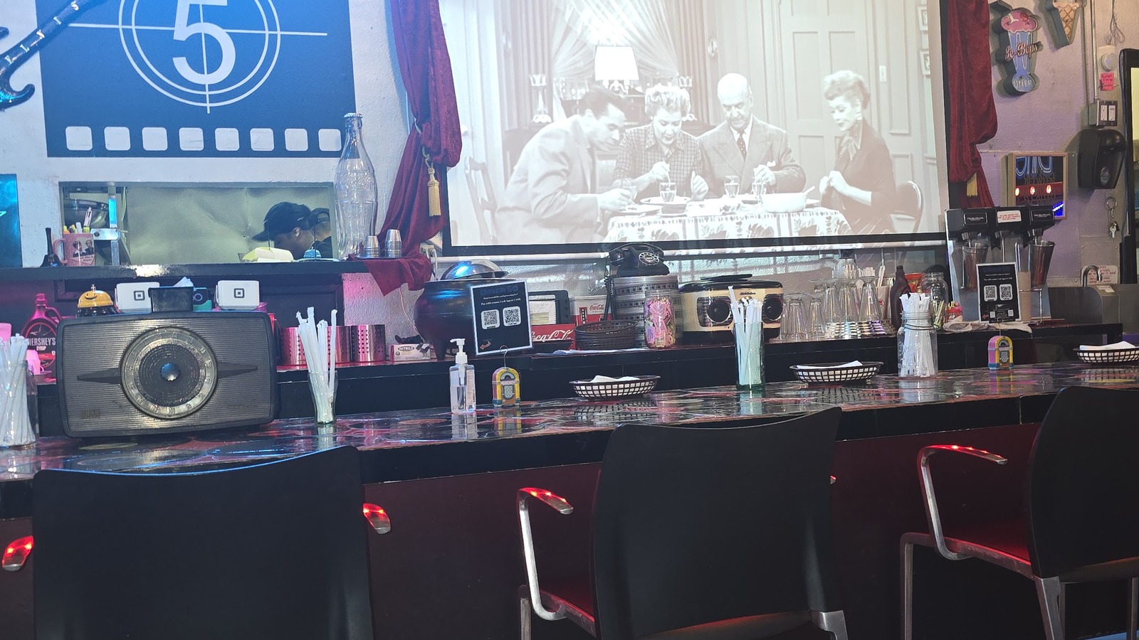 Black-and-white movie projection above the counter at Diner 50
