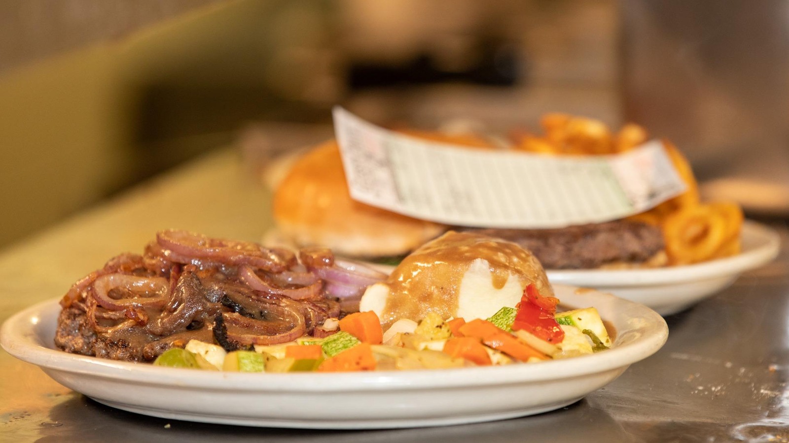 Lunch plate with grilled onions, vegetables, and a sandwich at Coffee Pot Restaurant