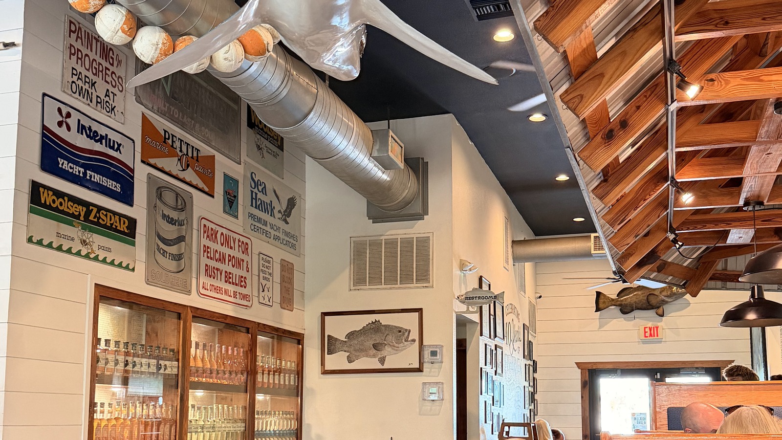 A shark suspended over nautical signs and wood trim inside Rusty Bellies