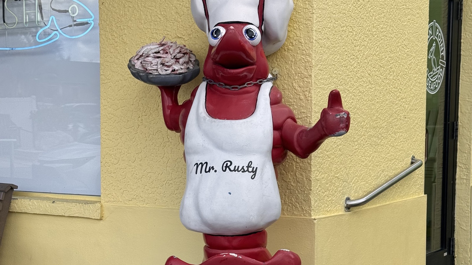 Mr. Rusty the lobster statue holding shrimp outside Rusty Bellies in Tarpon Springs