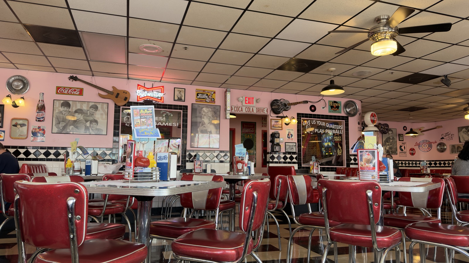 Red chairs, chrome tables, and pink diner walls inside Little Anthony's Diner