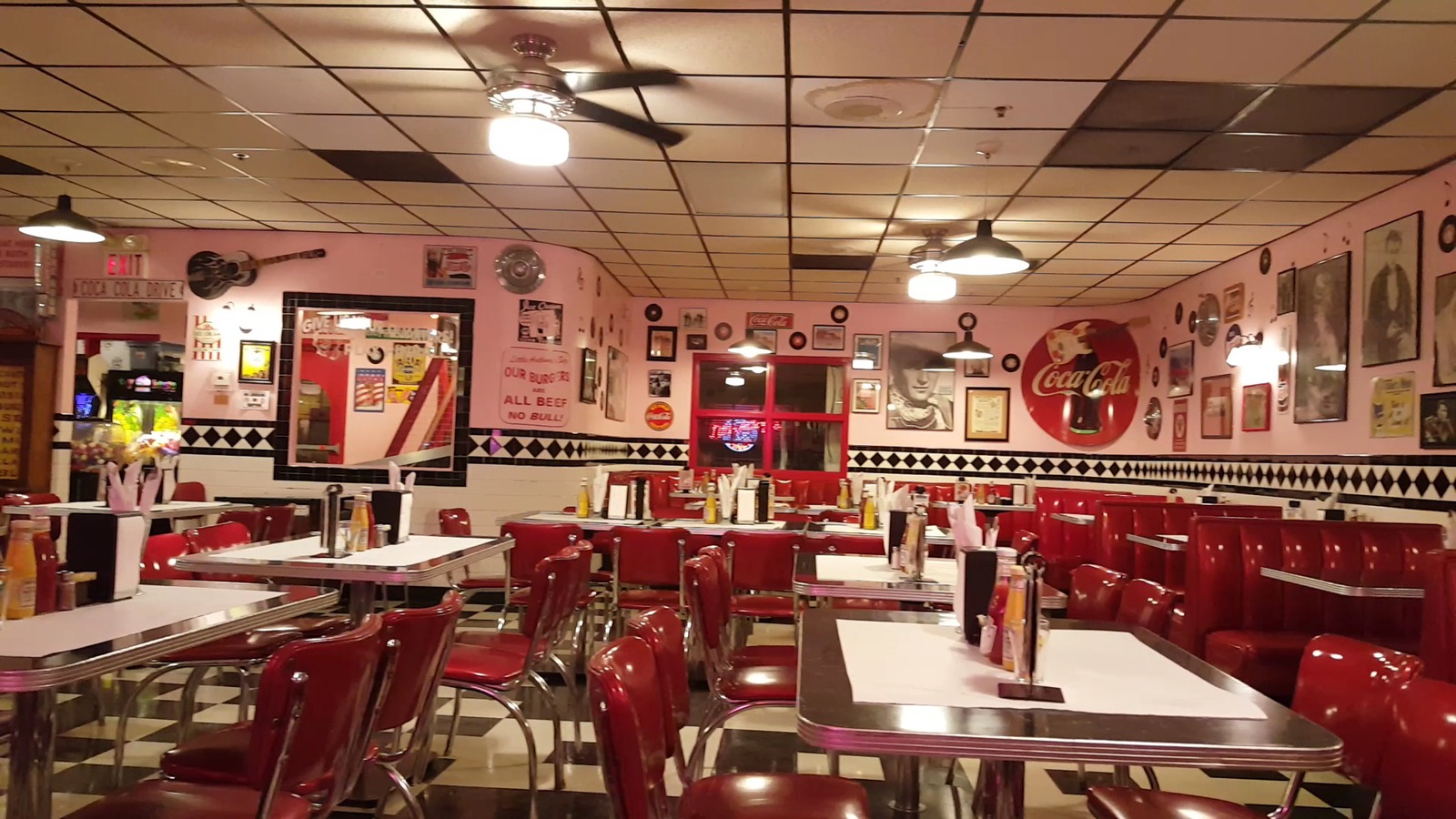 Red booths and pink walls glowing inside Little Anthony's Diner at night