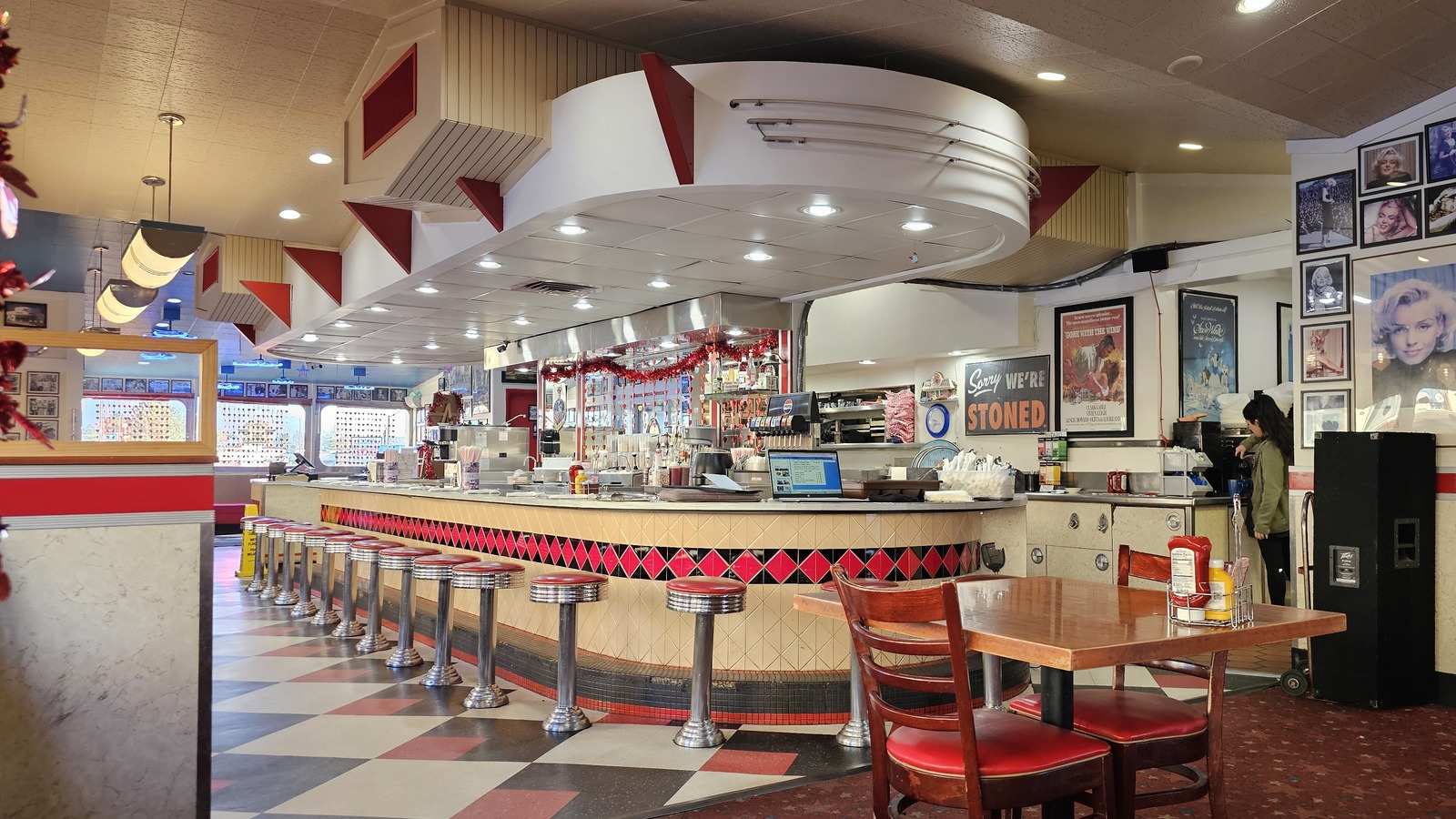 Long counter, checkerboard floor, and chrome stools inside Galaxy Diner