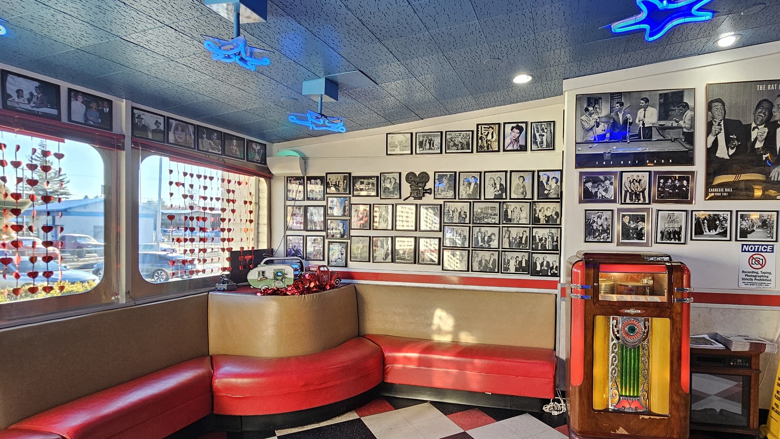 Curved red booth, jukebox, and vintage photo wall inside Galaxy Diner