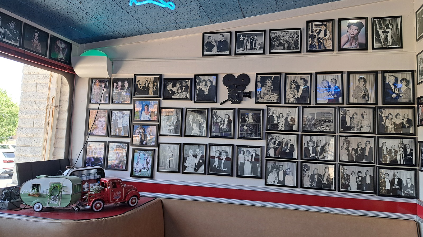 Wall of classic Hollywood photos beneath blue airplane lights at Galaxy Diner