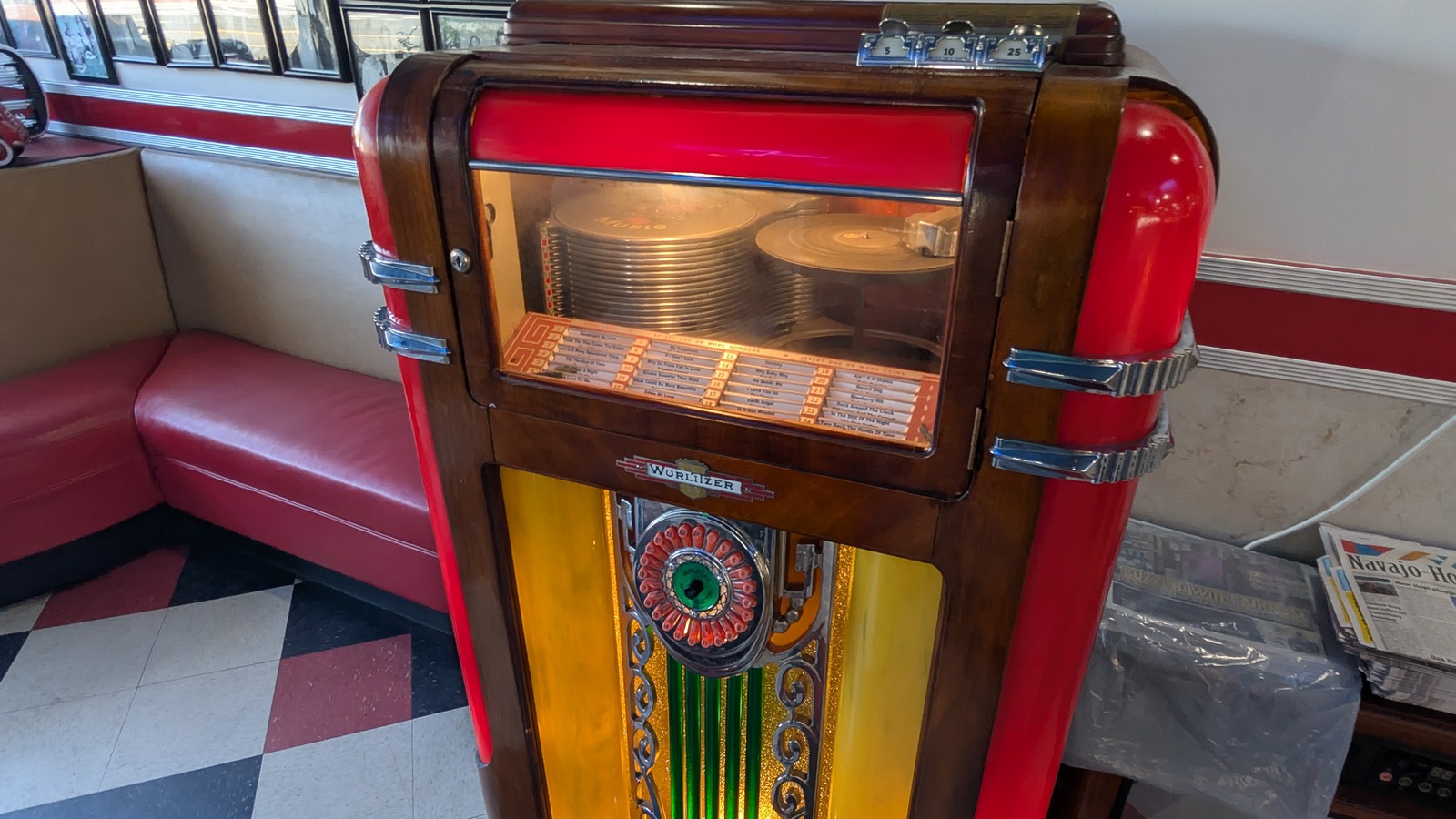 Vintage Wurlitzer jukebox beside red booths and black-and-white tile at Galaxy Diner