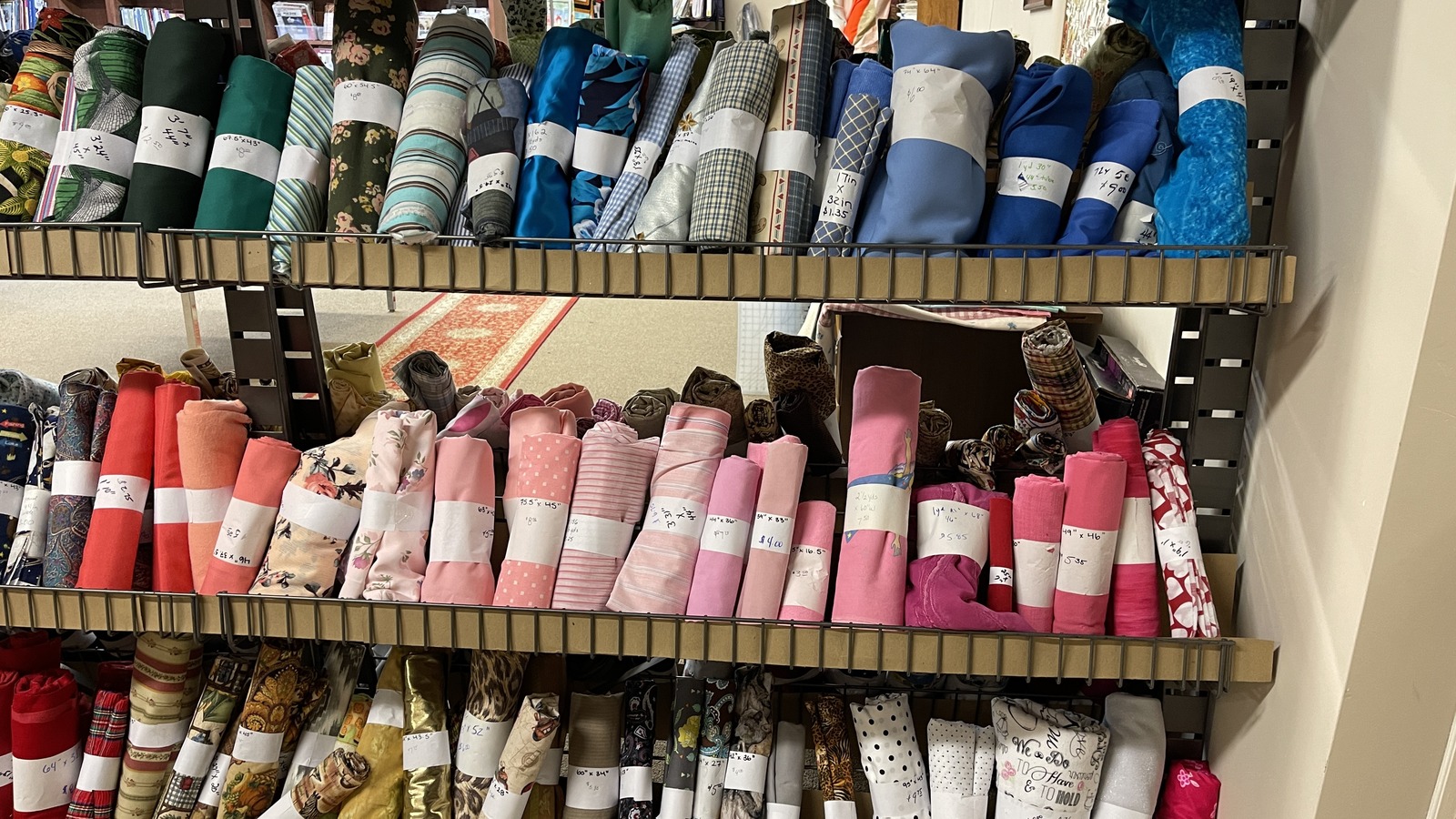 Shelves of rolled fabric and textiles inside Lancaster Creative Reuse in Lancaster