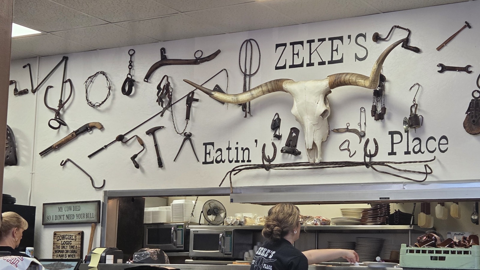 Longhorn skull, branding irons, and open counter inside Zeke's Eatin' Place