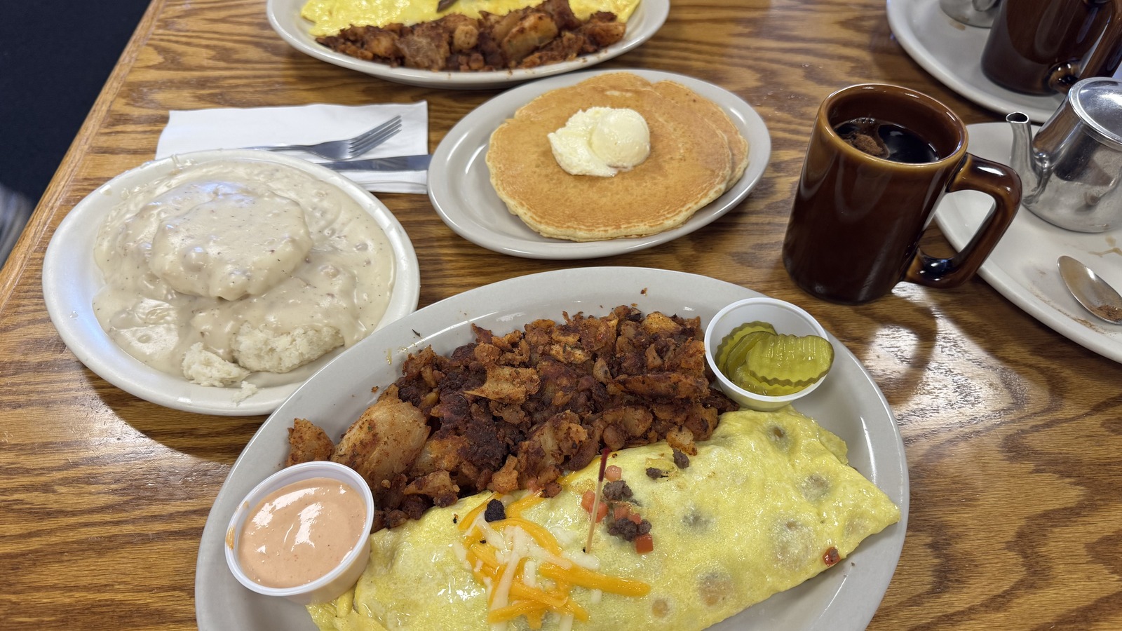 Omelet, pancakes, biscuits and gravy, hashbrowns, and coffee on a breakfast table at Zeke's Eatin' Place