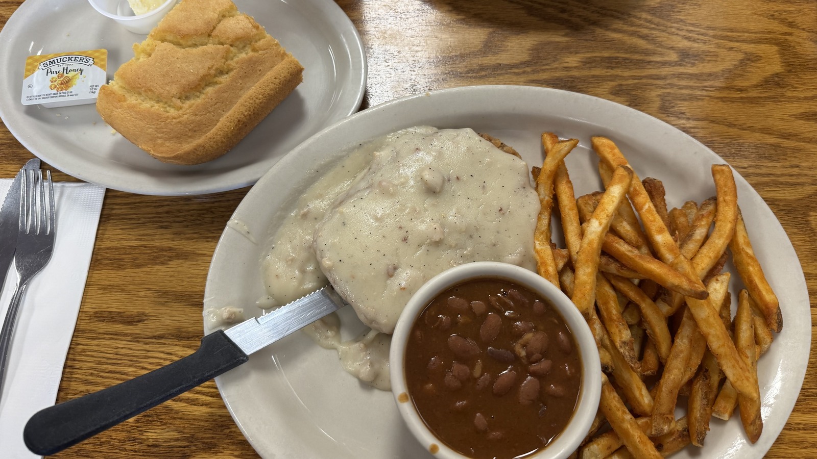 Chicken fried steak with country gravy, fries, beans, and cornbread at Zeke's Eatin' Place