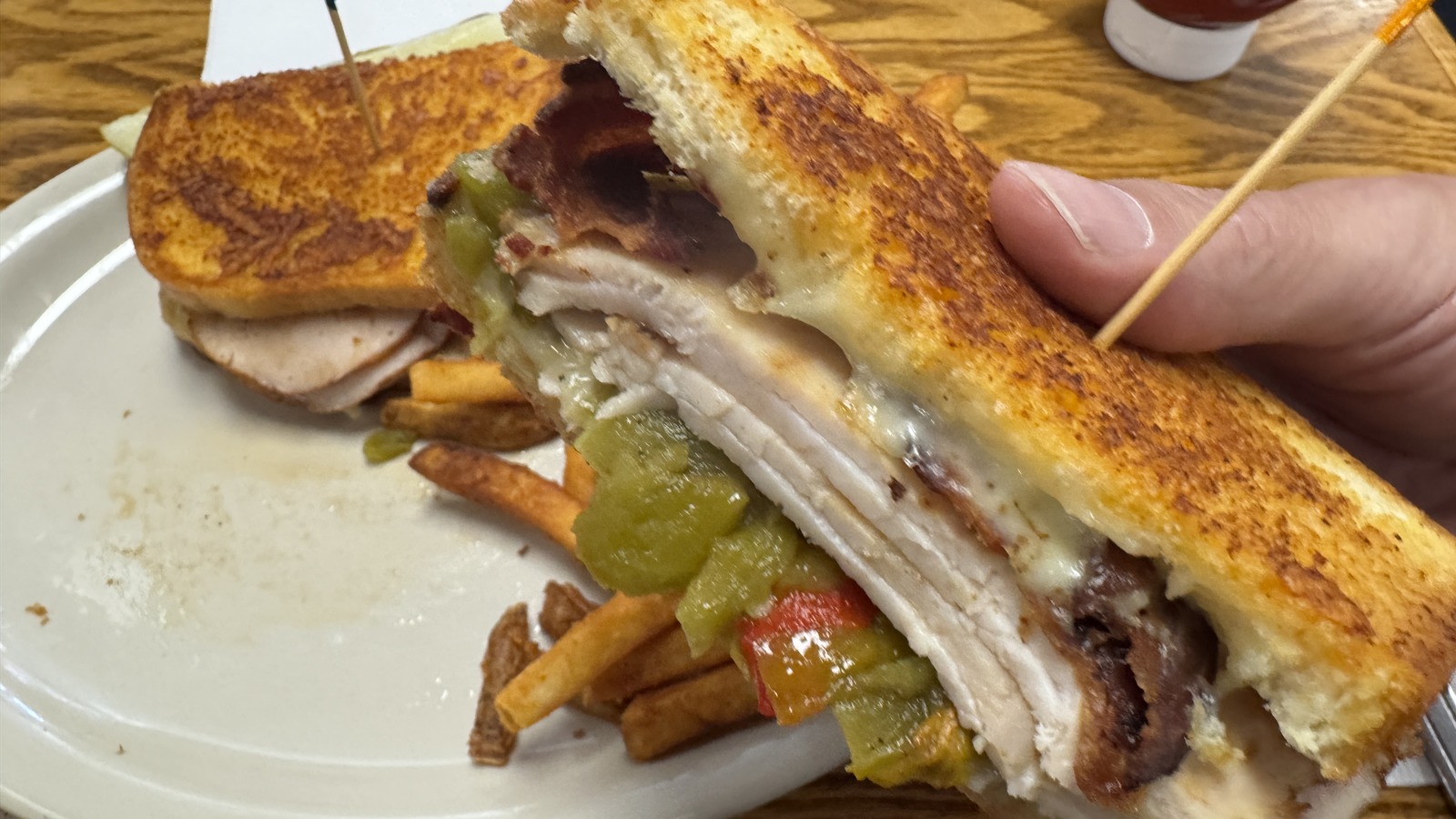 Toasted sandwich with bacon, melted cheese, and fries at Zeke's Eatin' Place