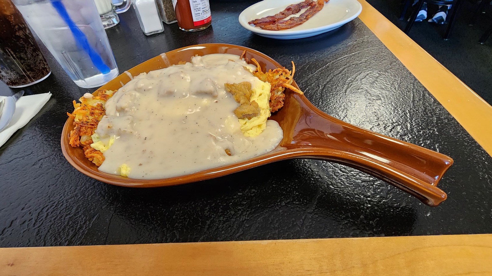 Country gravy over eggs and hashbrowns in a skillet-style dish at Zeke's Eatin' Place
