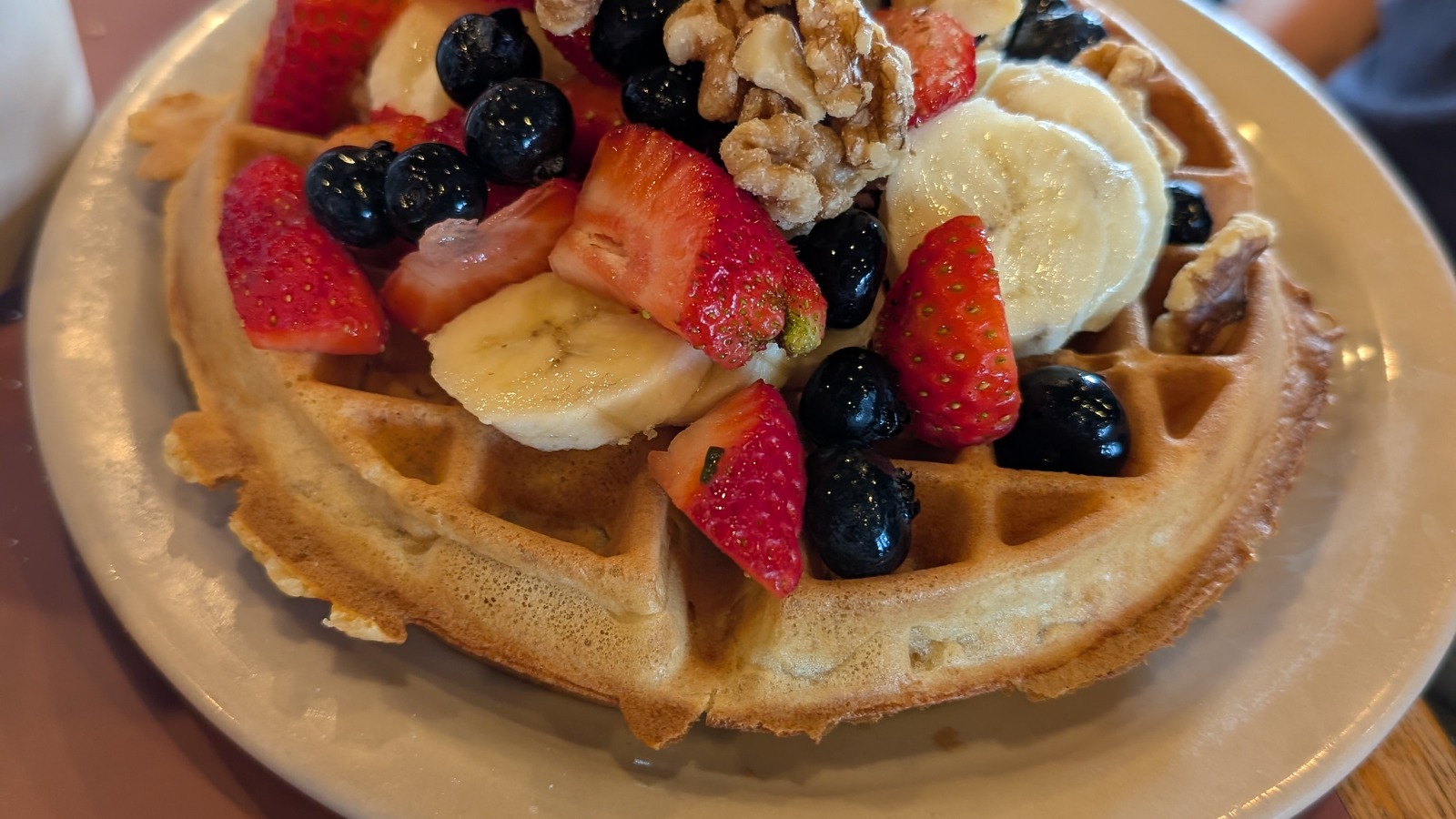 Fruit-topped waffle served on a teal tabletop at Randy's Restaurant & Ice Cream