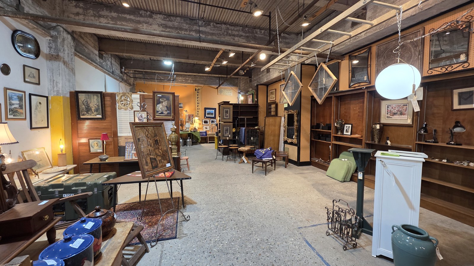 Wide aisle of furniture, frames, and art inside Midland Arts & Antiques Market in Indianapolis