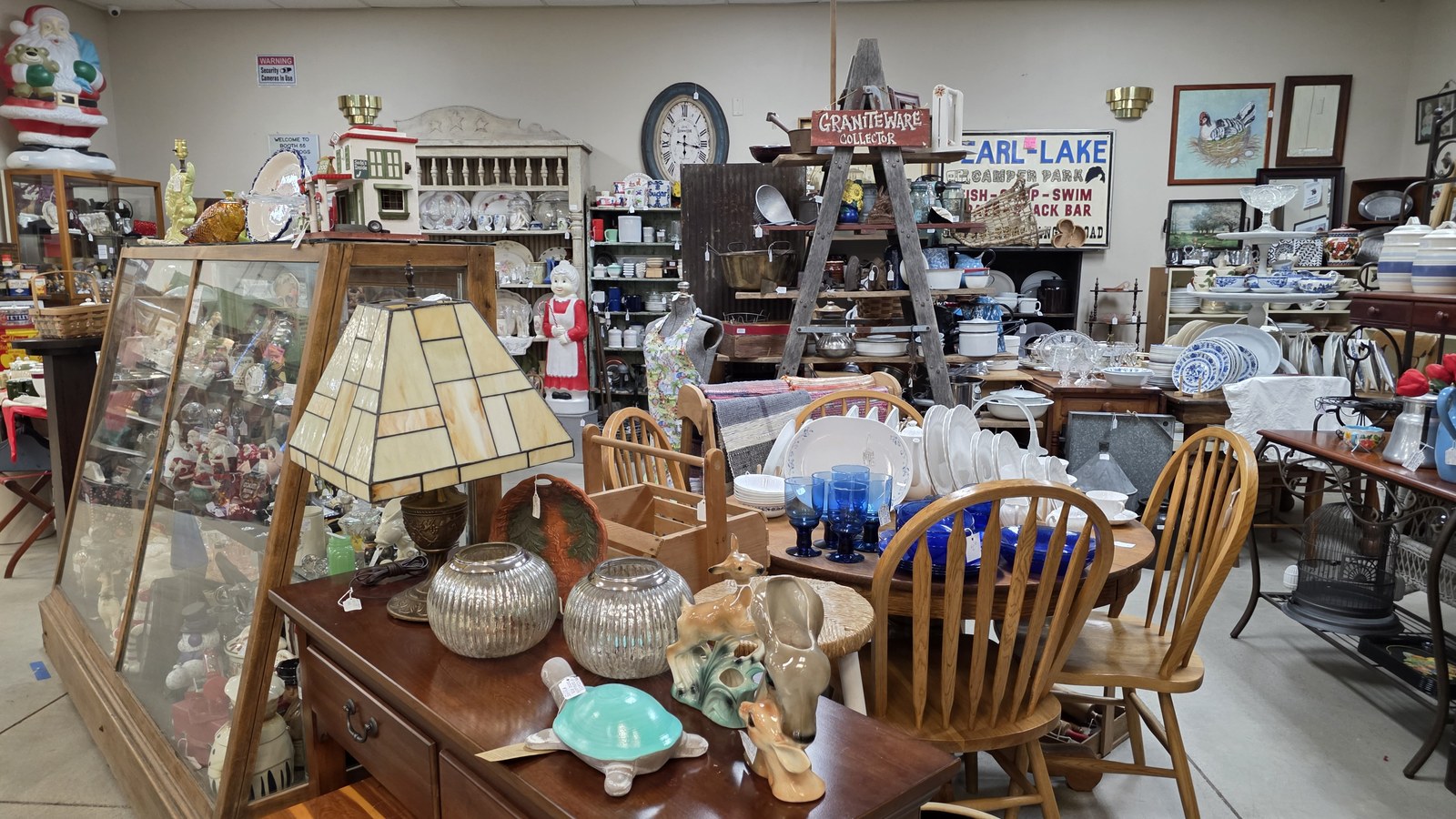 Dining table, glassware, signs, and furniture inside Vintage Treasures Antique Mall in Fort Wayne