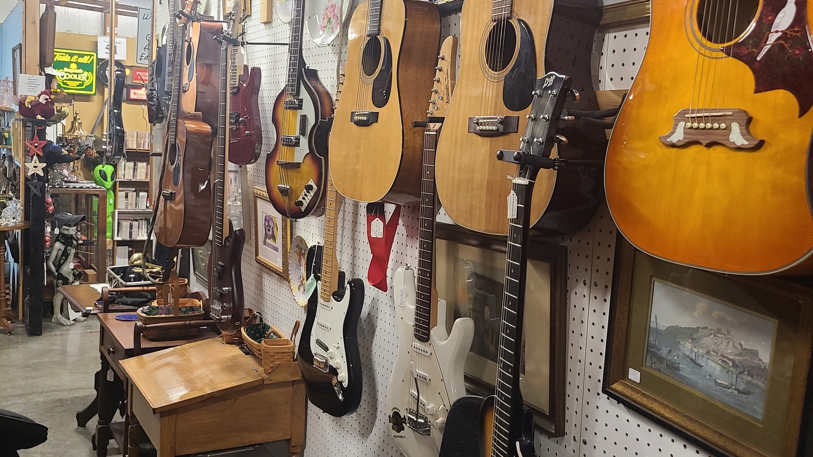 Row of acoustic and electric guitars inside Gilley's Antique & Decorator Mall in Plainfield
