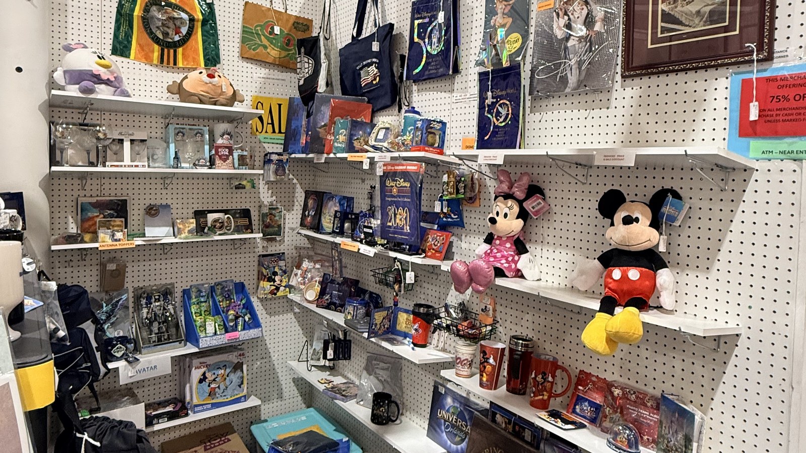 Pop-culture booth with Disney plush characters, music memorabilia, and boxed collectibles at Exit 76 Antique Mall