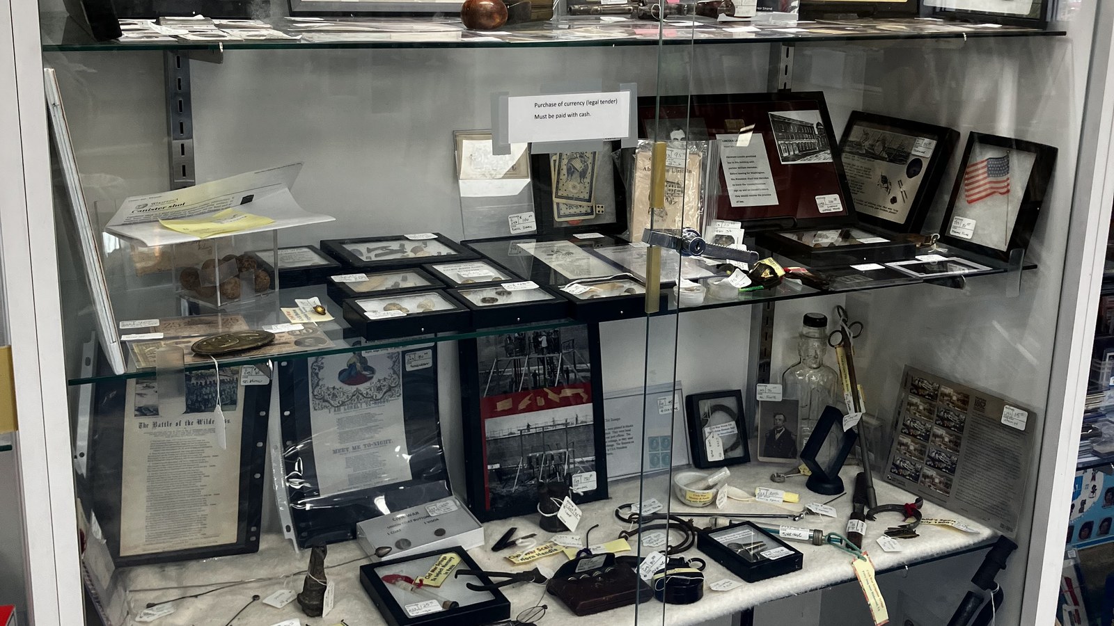 Glass display case filled with historical documents, medals, and military-era artifacts at Exit 76 Antique Mall