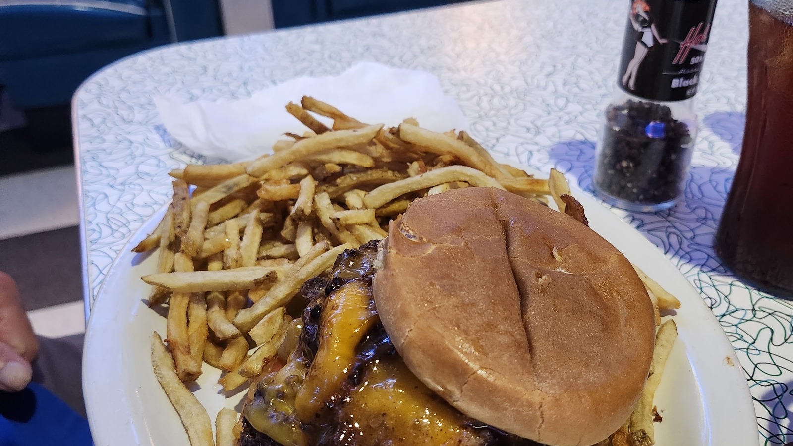 Cheeseburger and fries served in a blue booth at Hot Rods 50's Diner