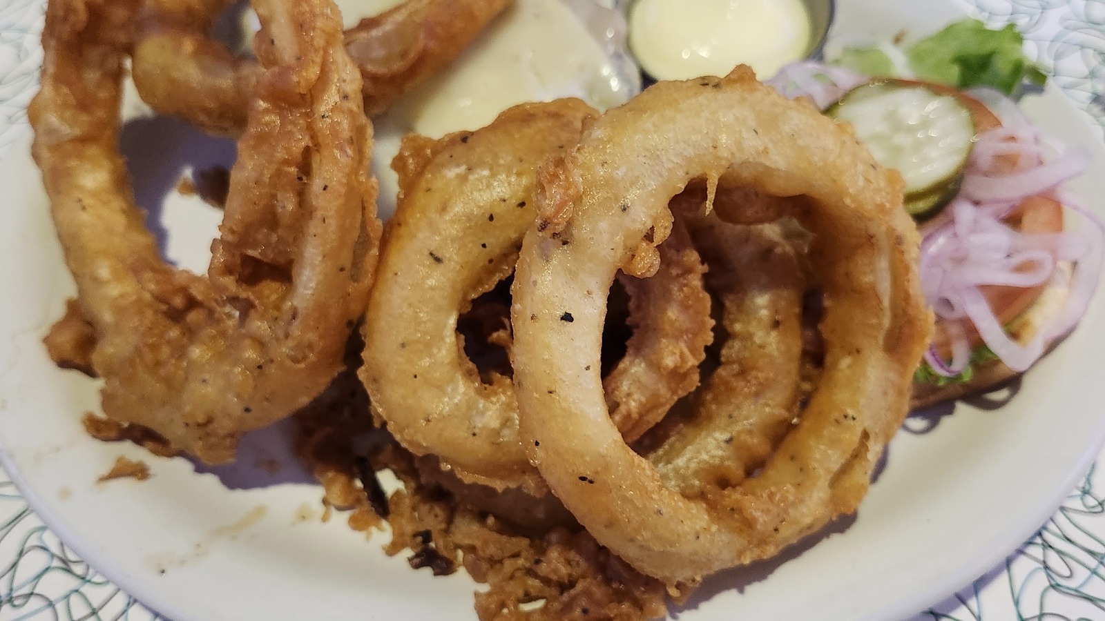 Golden onion rings stacked on a diner plate at Hot Rods 50's Diner