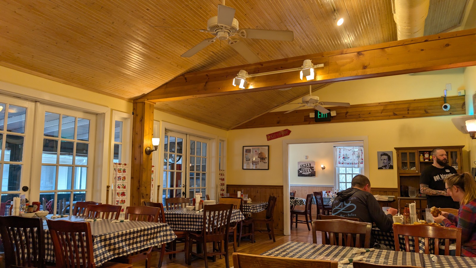 Wood-ceiling dining room with blue-check tablecloths inside The Loveless Cafe